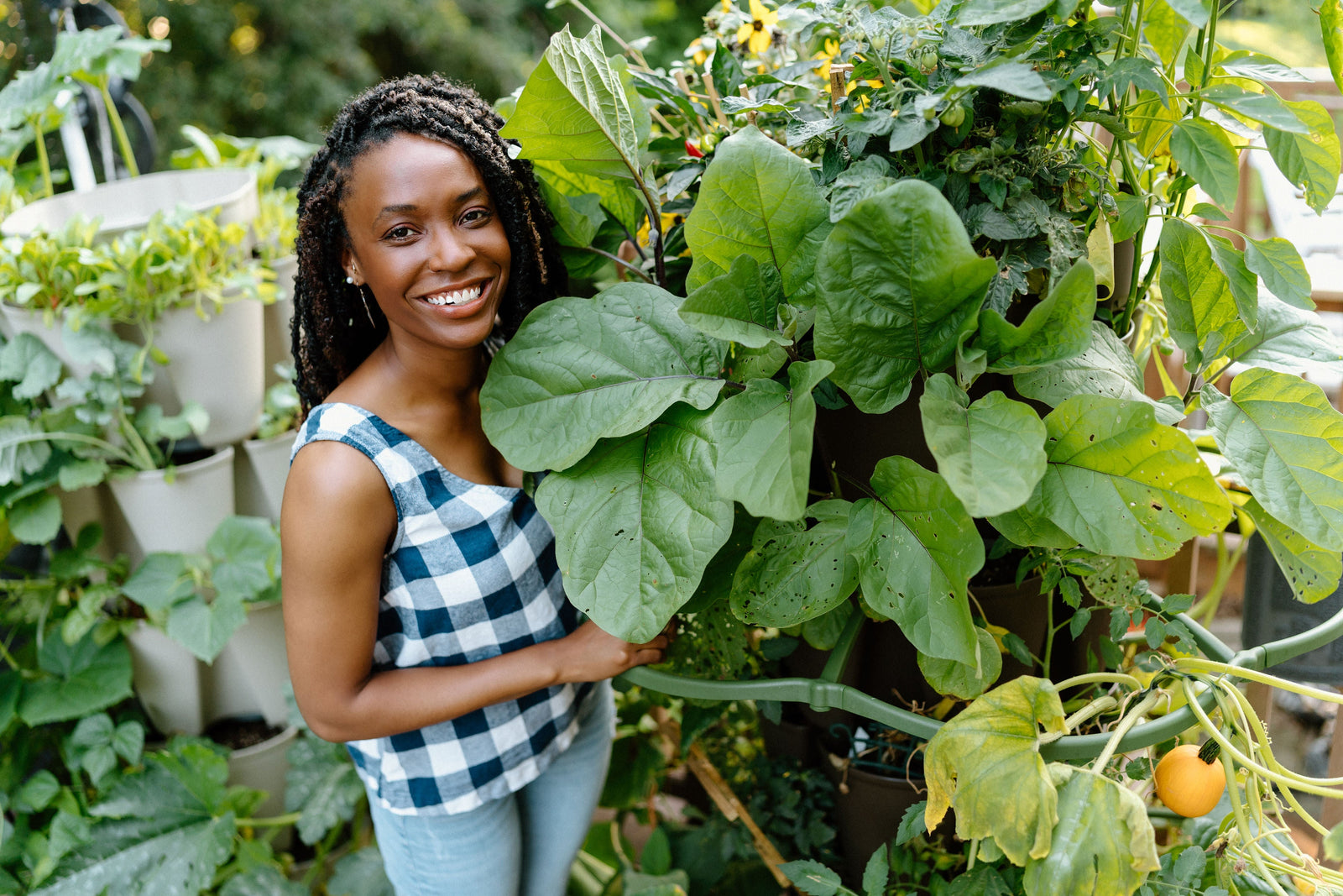 Cassandra standing next to her lush deck garden